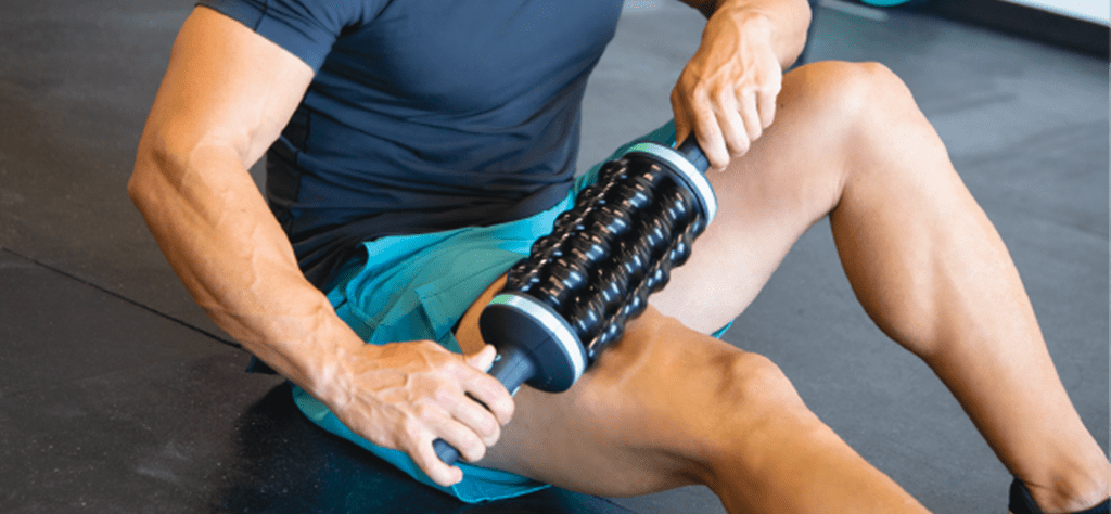 Person exercising with muscle roller tool